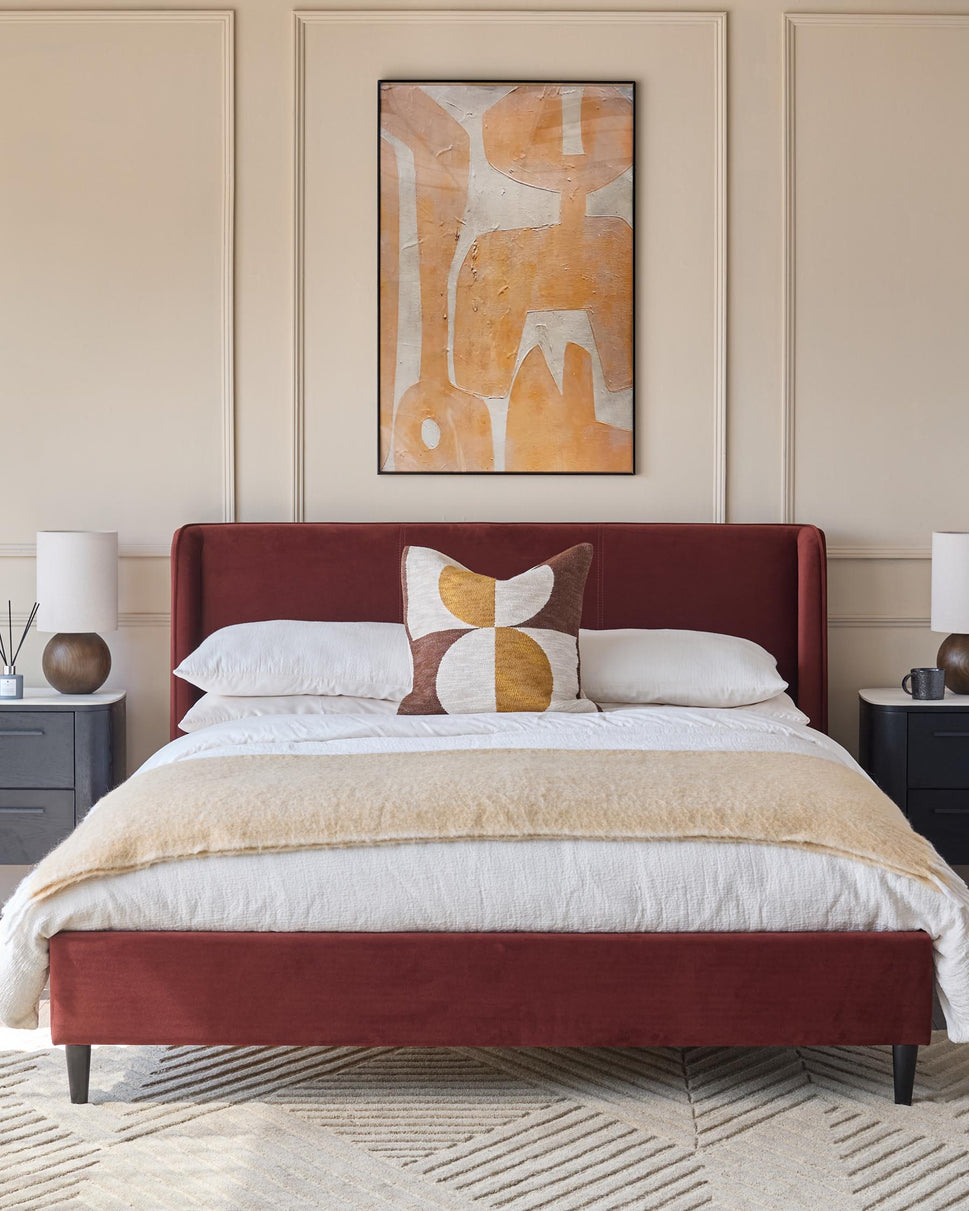 A red bed, matching headboard, bedside tables and lamps create a cosy bedroom look.