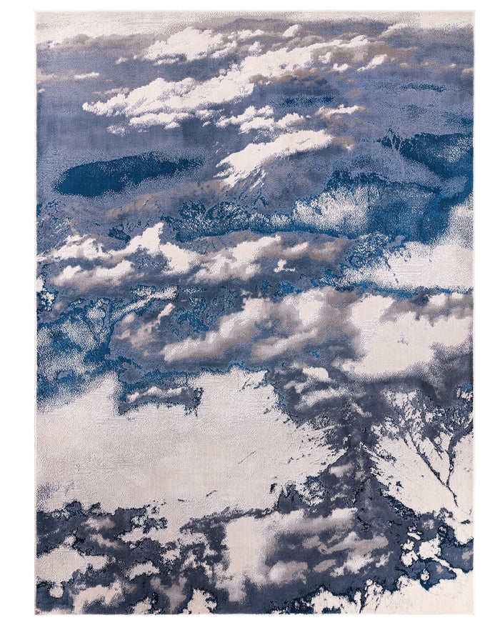 Perla medium rug with aerial cloud landscape design in soft metallics and dark navy tones on textured surface.