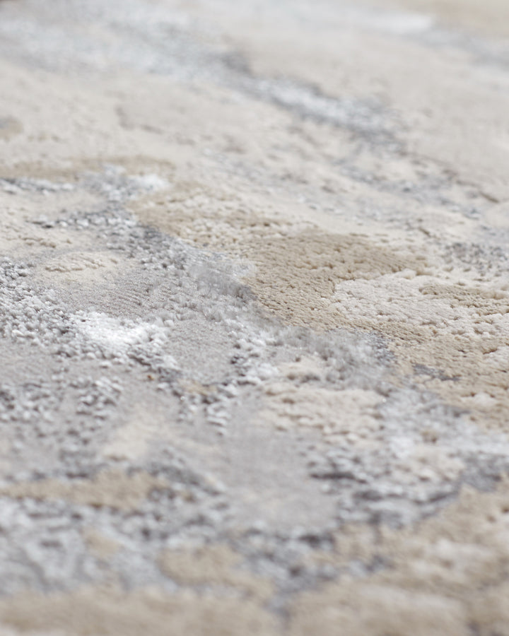 Close-up of a textured, neutral-toned rug with a subtle pattern, showcasing its soft pile and quality craftsmanship.