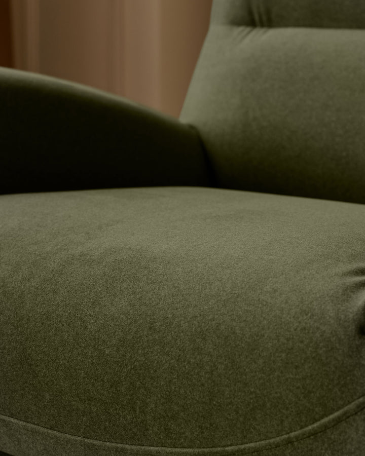 Piper accent chair in velvet olive green, close-up of curved seat and armrest detail.