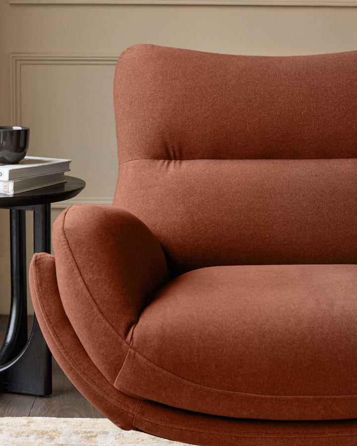Toffee-red Piper accent chair with curved armrests and high back, shown from side angle with matching footstool.