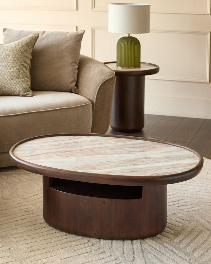 Rayna dark wood coffee table with oval top and Toronto marble surface, shown in living room setting.