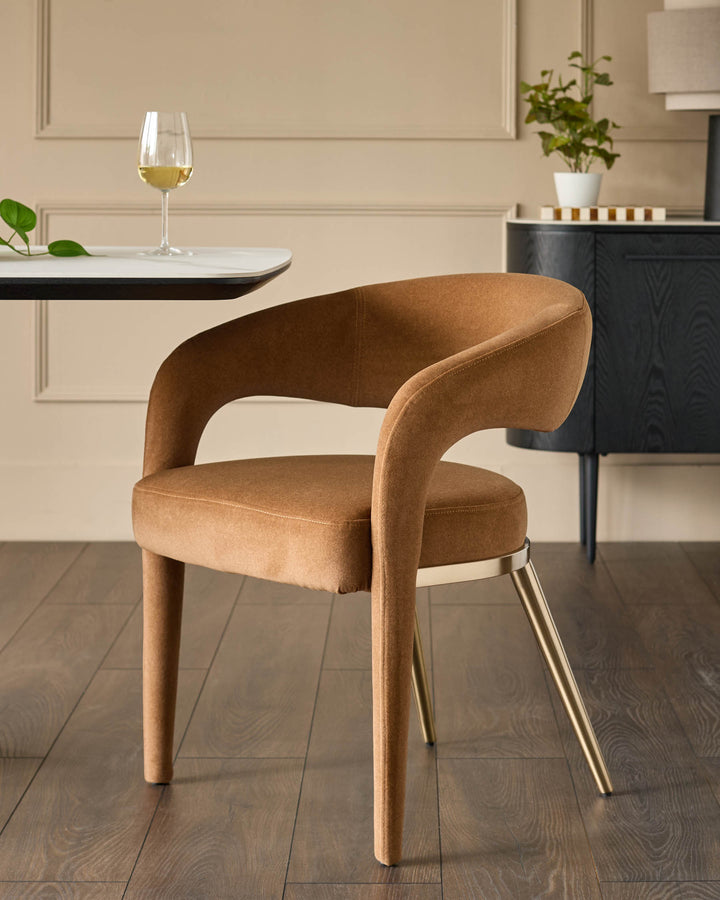 Upholstered chair with gold legs, beside a table with a glass of wine. A sideboard is in the background.