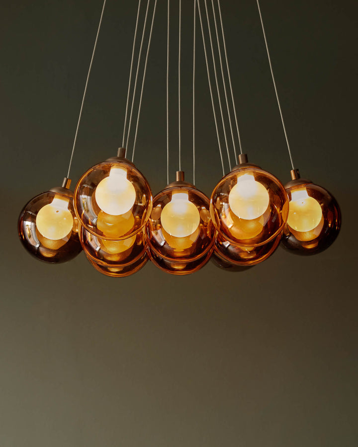 A cluster of spherical, amber pendant lights hang from thin wires, creating a warm and inviting glow.