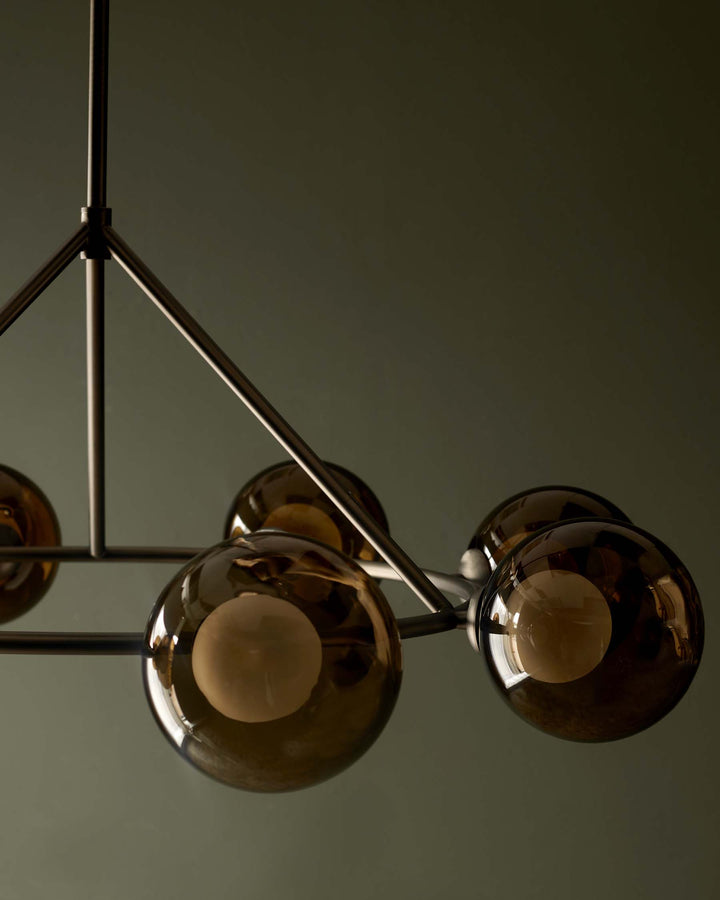 Contemporary ceiling light fixture featuring smoked glass globes and a sleek metal frame. Modern lighting for stylish interiors.