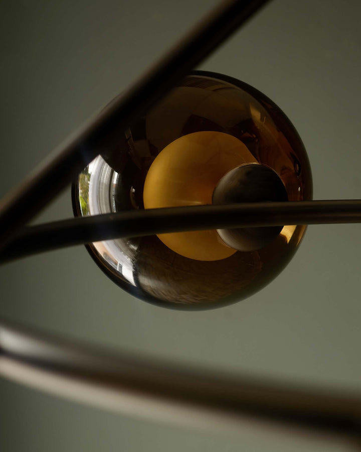 A modern light fixture with brown glass orbs and metal framework. Creates a stylish and contemporary aesthetic.