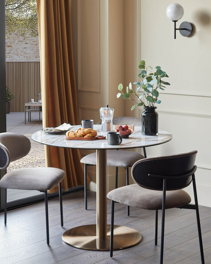 A stylish dining set with a round marble-topped table and elegant upholstered chairs. Perfect for modern dining rooms.