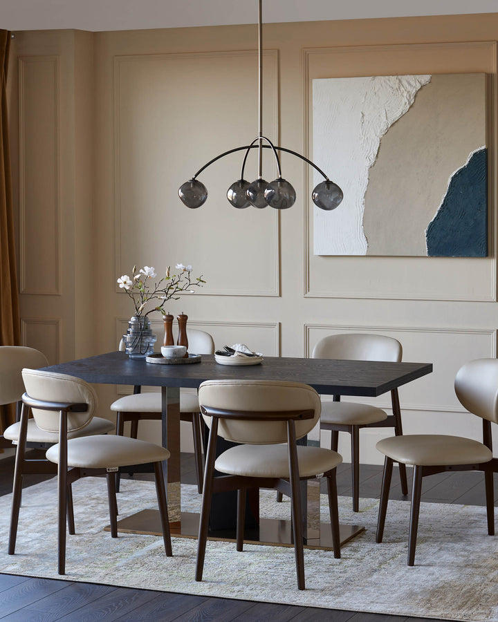 Dining room featuring a dark wood table, tan leather chairs, modern lighting, and an abstract art piece.