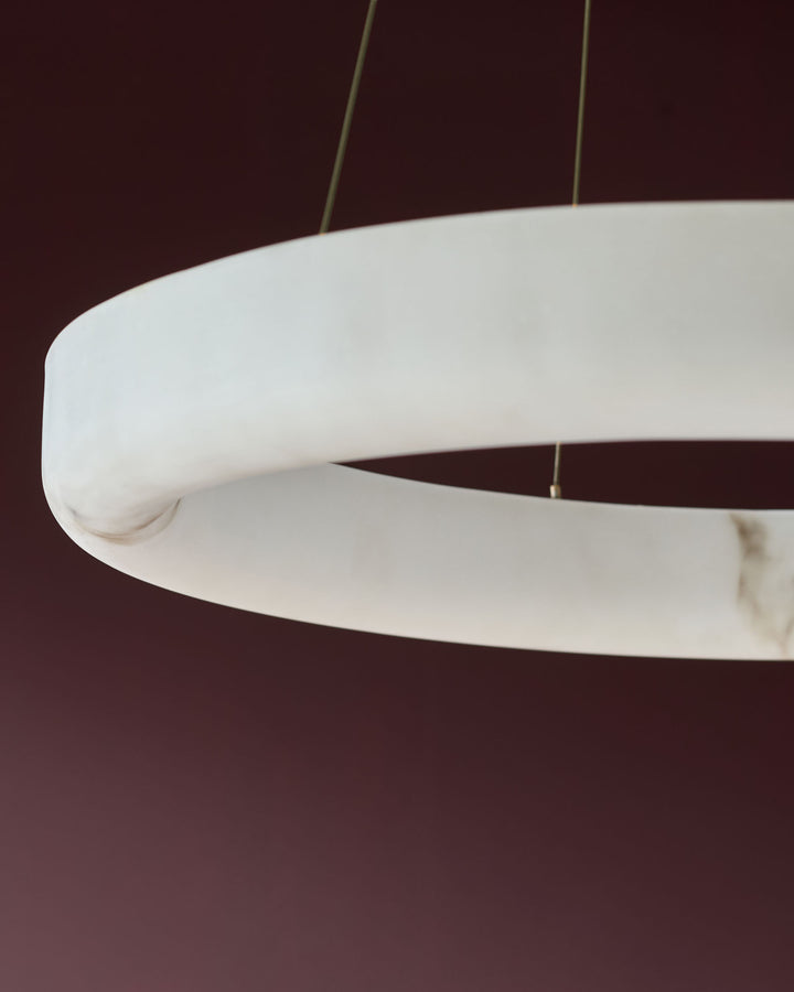 Sadie Small Pendant Light in alabaster effect natural finish, showing curved white shade with rounded edges and brass suspension wires.