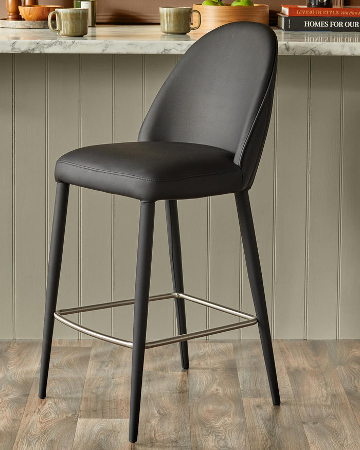 A stylish black bar stool with a sleek footrest, perfect for modern kitchens and dining spaces.