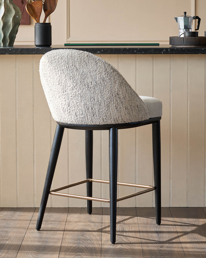 A stylish tweed bar stool with a circular back, sitting in a modern kitchen setting.