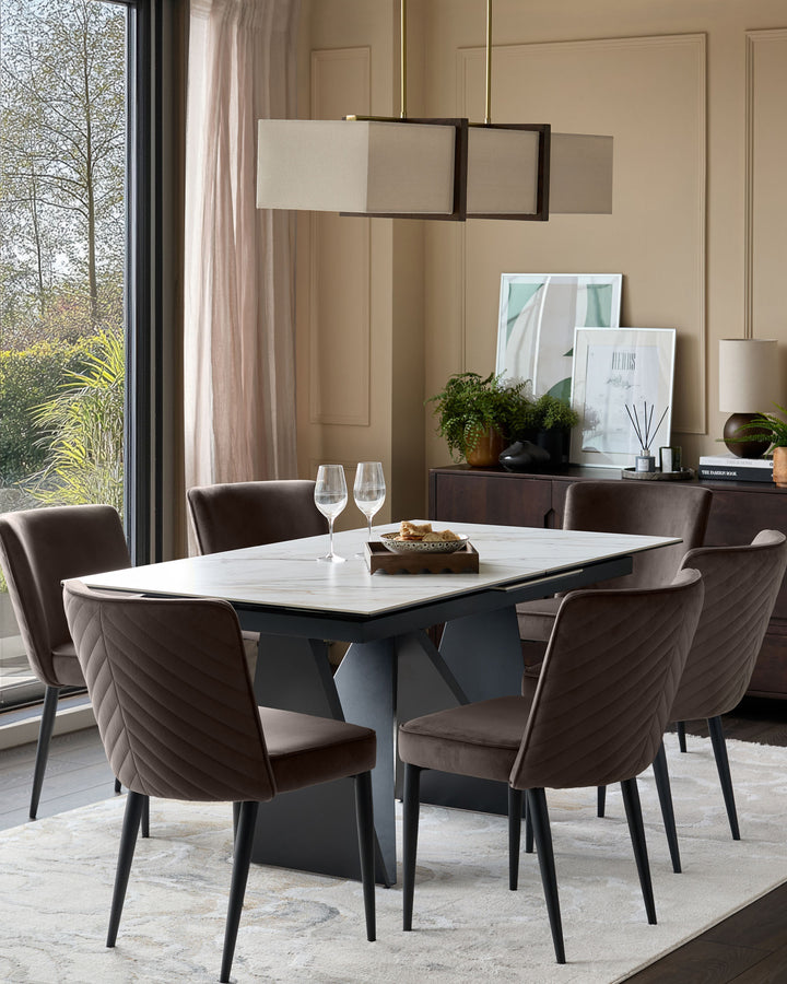 Mocha velvet dining chair with quilted backrest and black metal legs, shown in modern dining room setting.