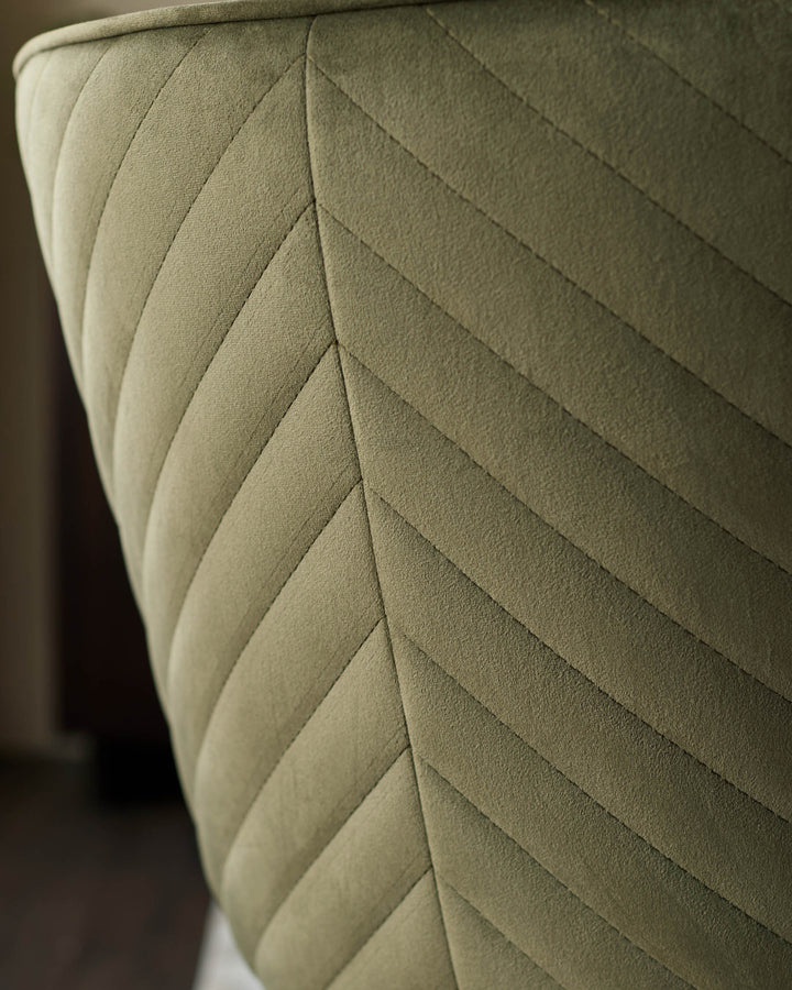 Close-up of a stylish chair back. Olive green, quilted, with a chevron pattern. Comfortable and modern furniture.