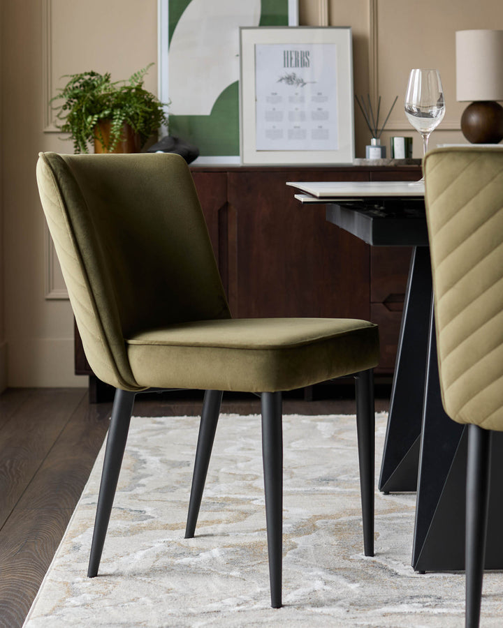 An olive green upholstered dining chair with black legs sits on a patterned rug, next to a table and sideboard.