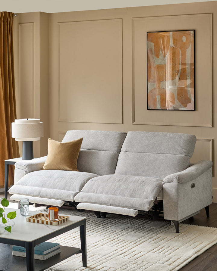 Serene 3-seater light grey fabric recliner sofa with both footrests extended, positioned in a neutral beige living room.