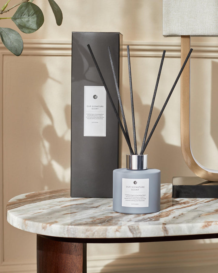 Elegant reed diffuser set on a marble table, featuring a sleek design and calming fragrance for a cosy home ambiance.