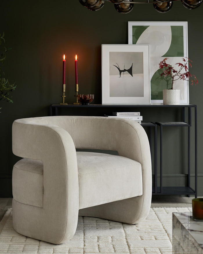 Contemporary interior with a snug, rounded armchair in pale neutral, styled with art and accessories.