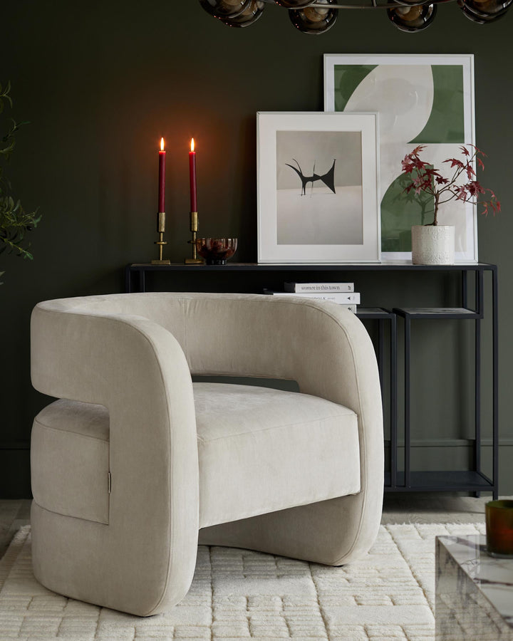 Contemporary interior with a snug, rounded armchair in pale neutral, styled with art and accessories.