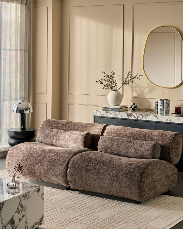 Sofia 2-seater sofa in mocha fabric with cylindrical bolster pillows, shown in a contemporary living room setting.