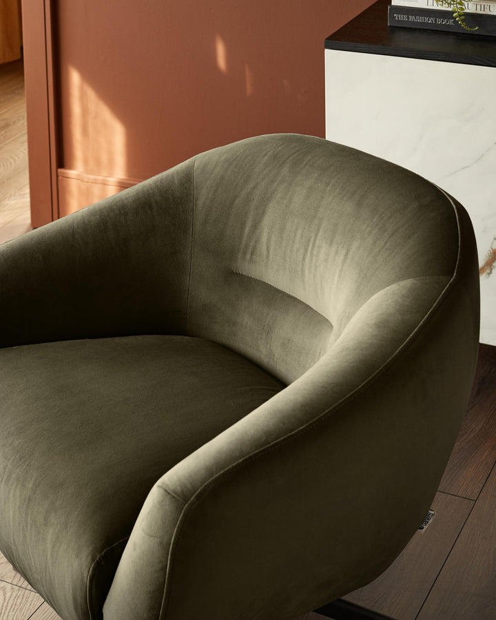 Close-up of a stylish olive green velvet armchair, showcasing its curved design and luxurious texture.