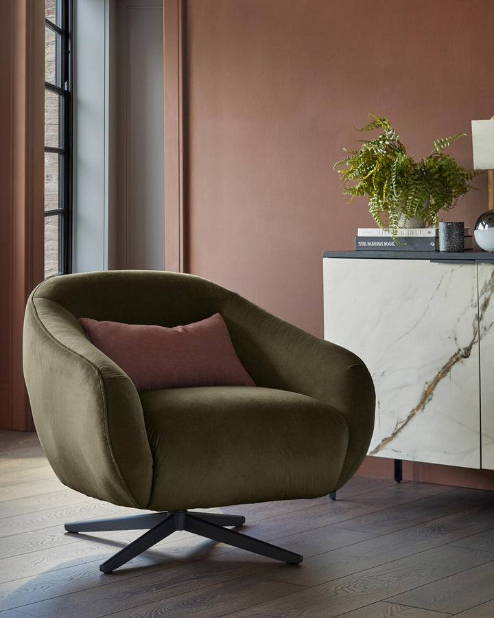 A stylish, olive-green swivel chair with a plum cushion sits beside a marble-effect cabinet, adding elegance to any modern home.