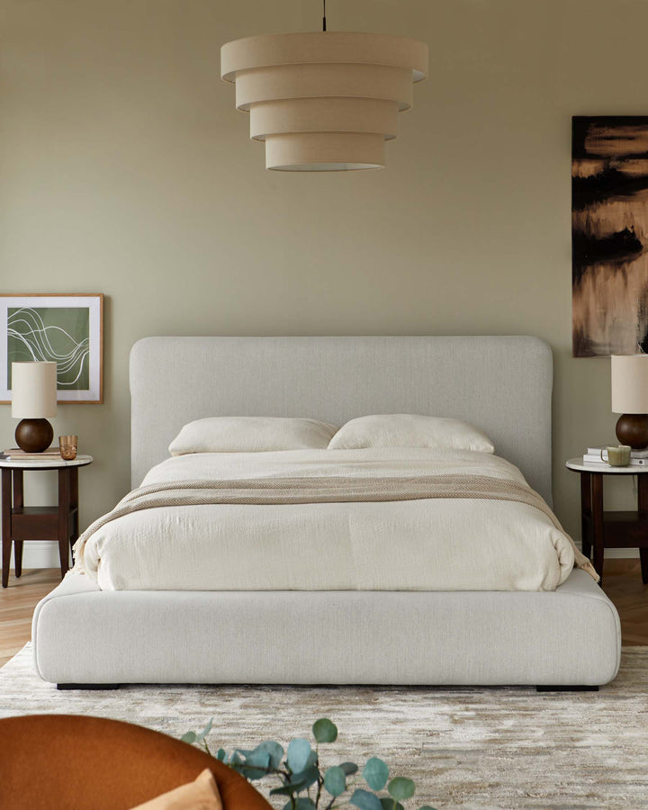 Bedroom scene with a large bed, bedside tables with lamps, and an abstract painting on the wall.