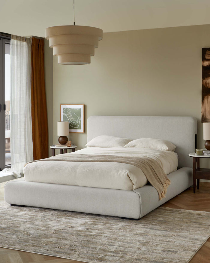 Contemporary bedroom features a platform bed, round side tables, layered pendant light and warm, neutral tones.