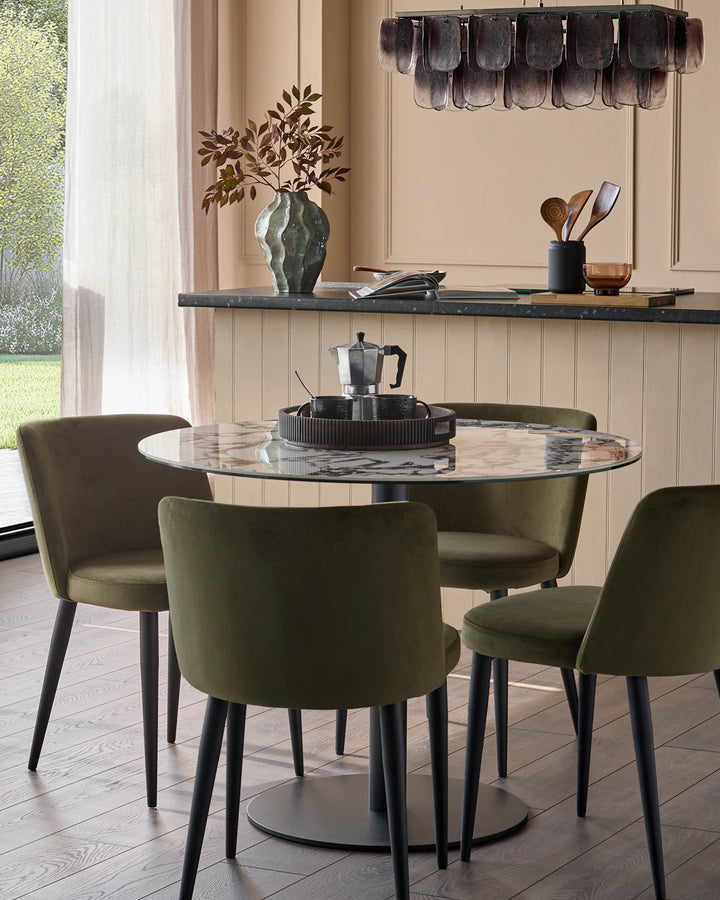 A dining set with four olive green chairs surrounding a round, marble-effect table with black legs and base.