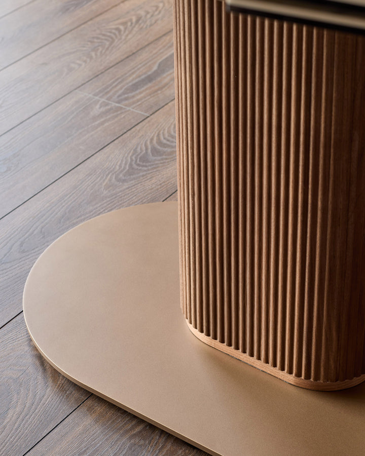 Vidal extending dining table with natural ceramic top and fluted wood base on wooden floor.