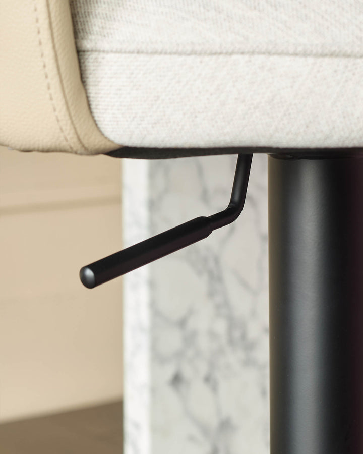 Wren gas lift bar stool with cream fabric seat, black curved footrest, and marble-effect base detail.