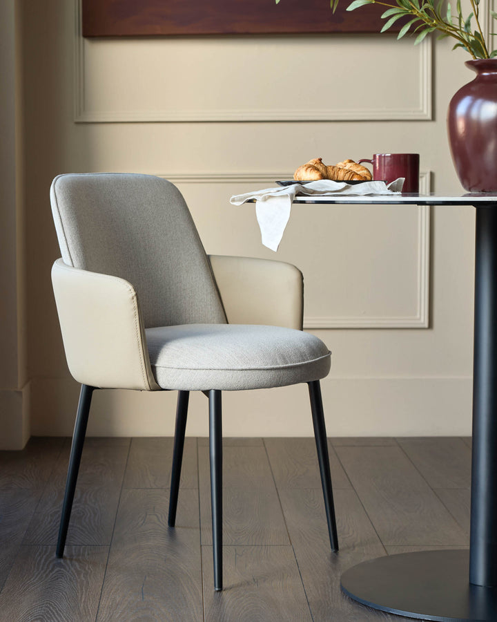 Wren dining chair in natural fabric and faux leather, featuring Grey upholstery, black tapered legs, and curved armrests.