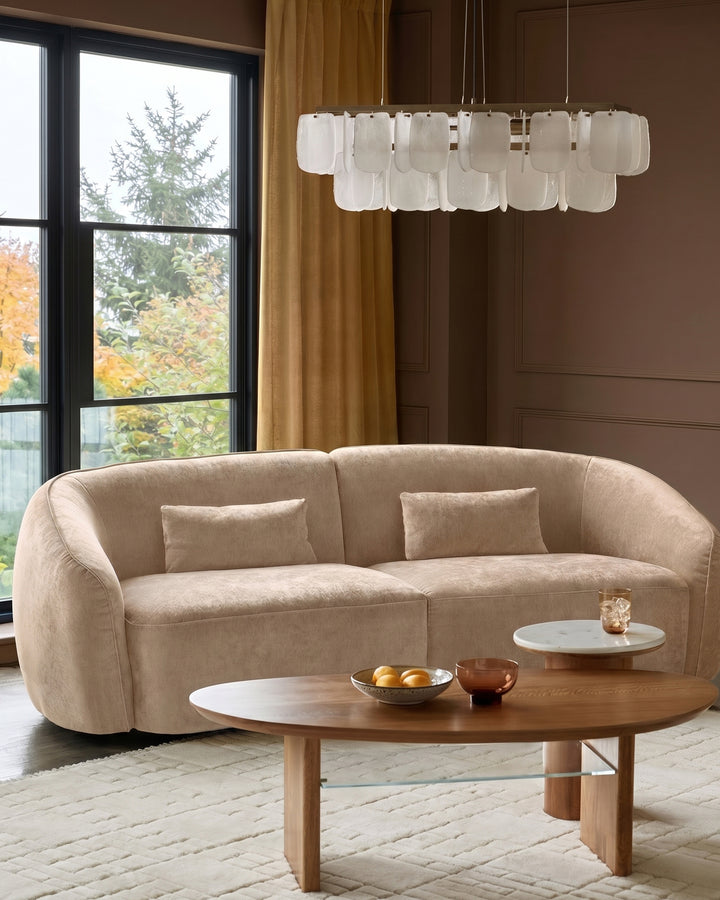 Champagne fabric curved 3-seater sofa with rounded arms and back, styled in a modern living room setting.