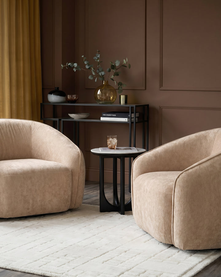 Zoey armchair in champagne fabric with curved design, shown in a styled living room setting.