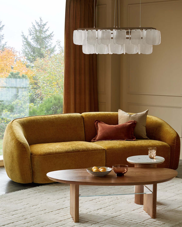 A stylish living room featuring a mustard sofa, wooden coffee table and accent side table.
