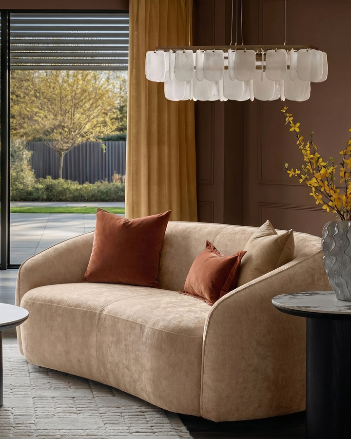 Champagne Zoey 2-seater sofa with curved arms and plush cushions, styled in a modern living room setting.