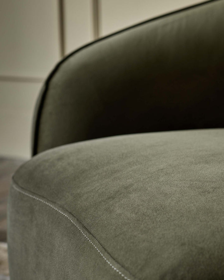 Close-up of a lush, olive-green velvet chair with detailed stitching. Luxurious comfort and classic design.