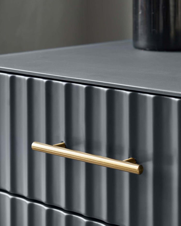 Contemporary dark grey chest of drawers featuring a textured vertical rib design and a brushed gold metal handle.