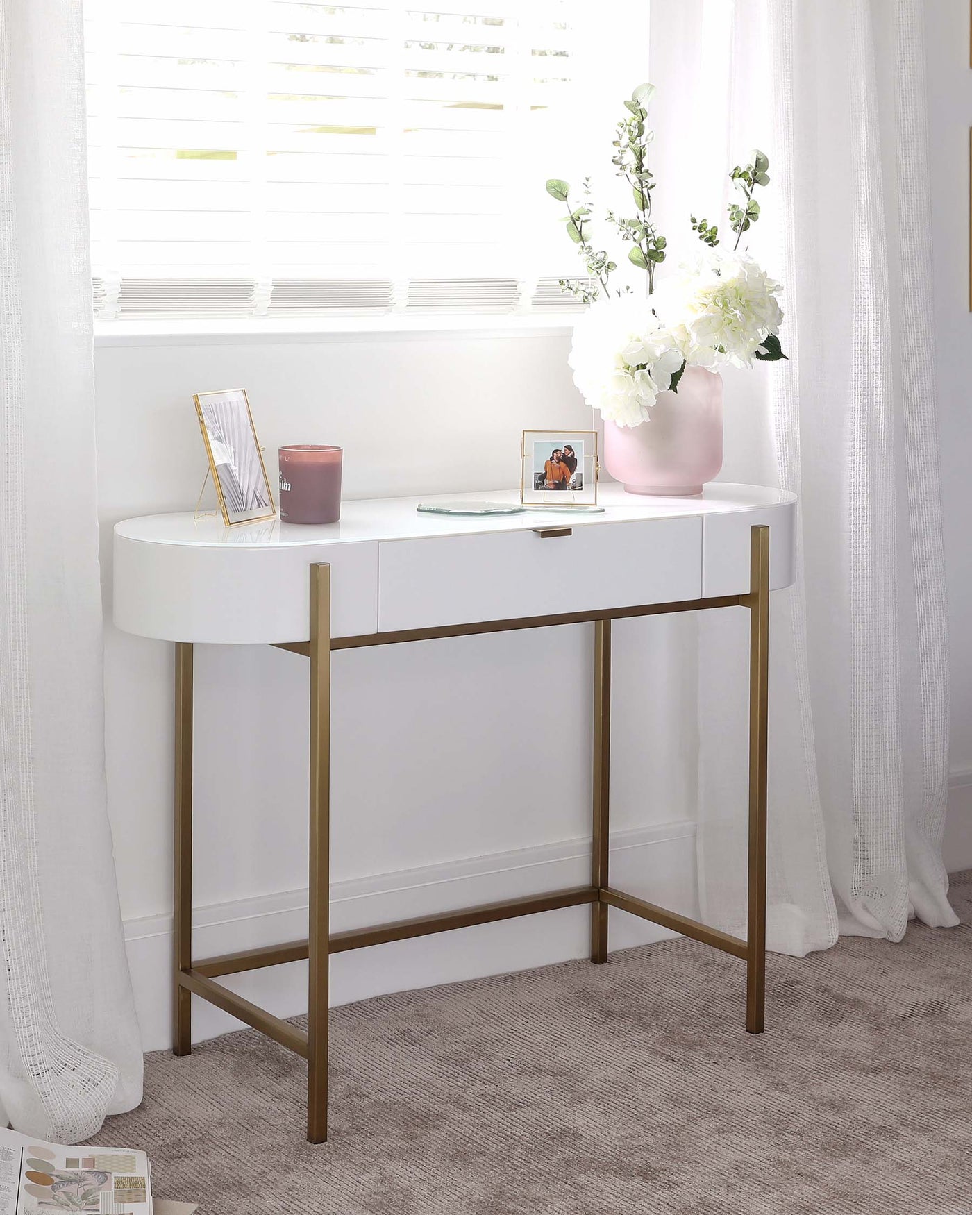 Elegant modern white console table with a curved tabletop edge and sleek golden metal legs, featuring a minimalist design ideal for contemporary interiors.