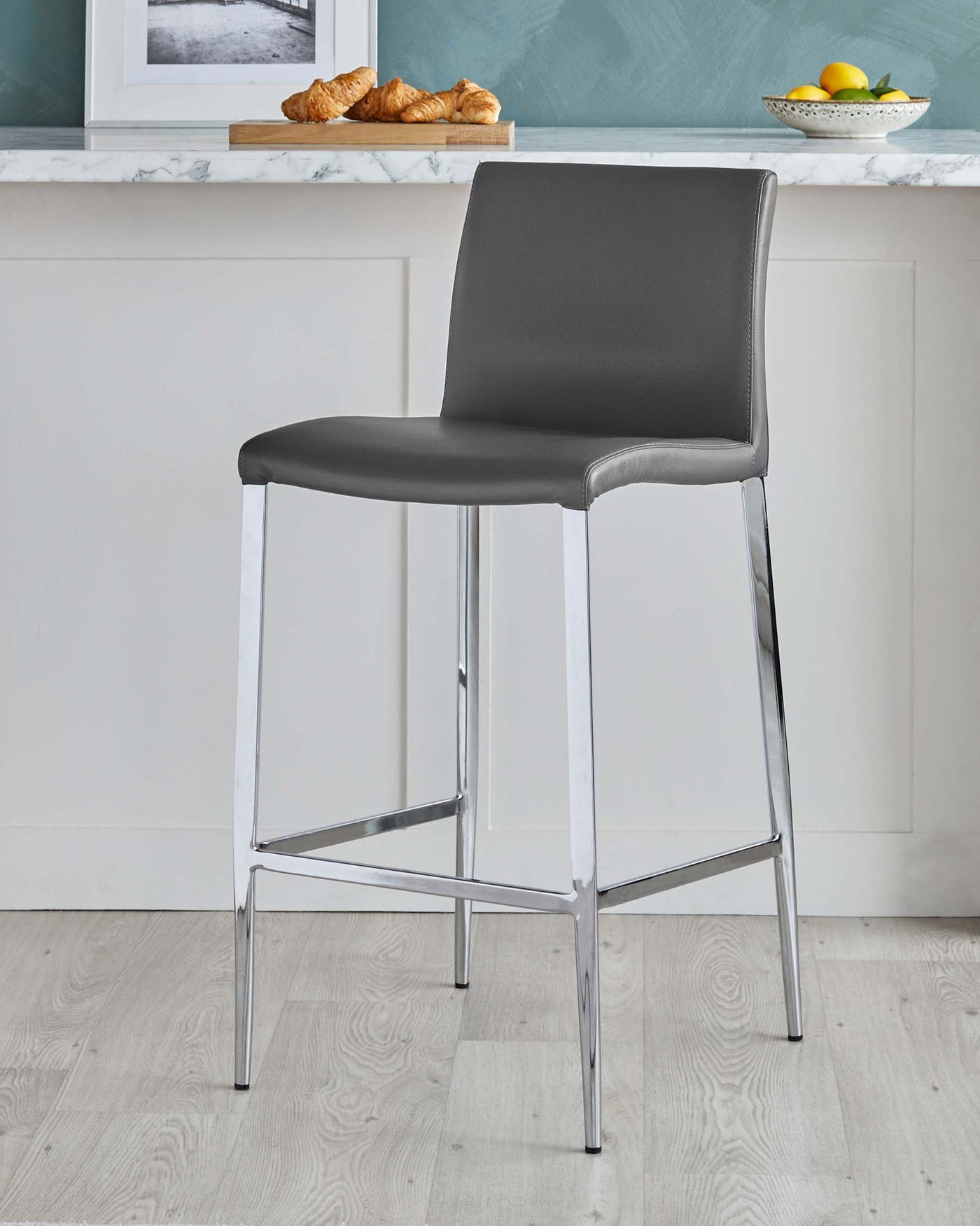 Modern black leatherette bar stool with a chrome-plated steel frame, featuring a high backrest and slender legs with a square footrest.