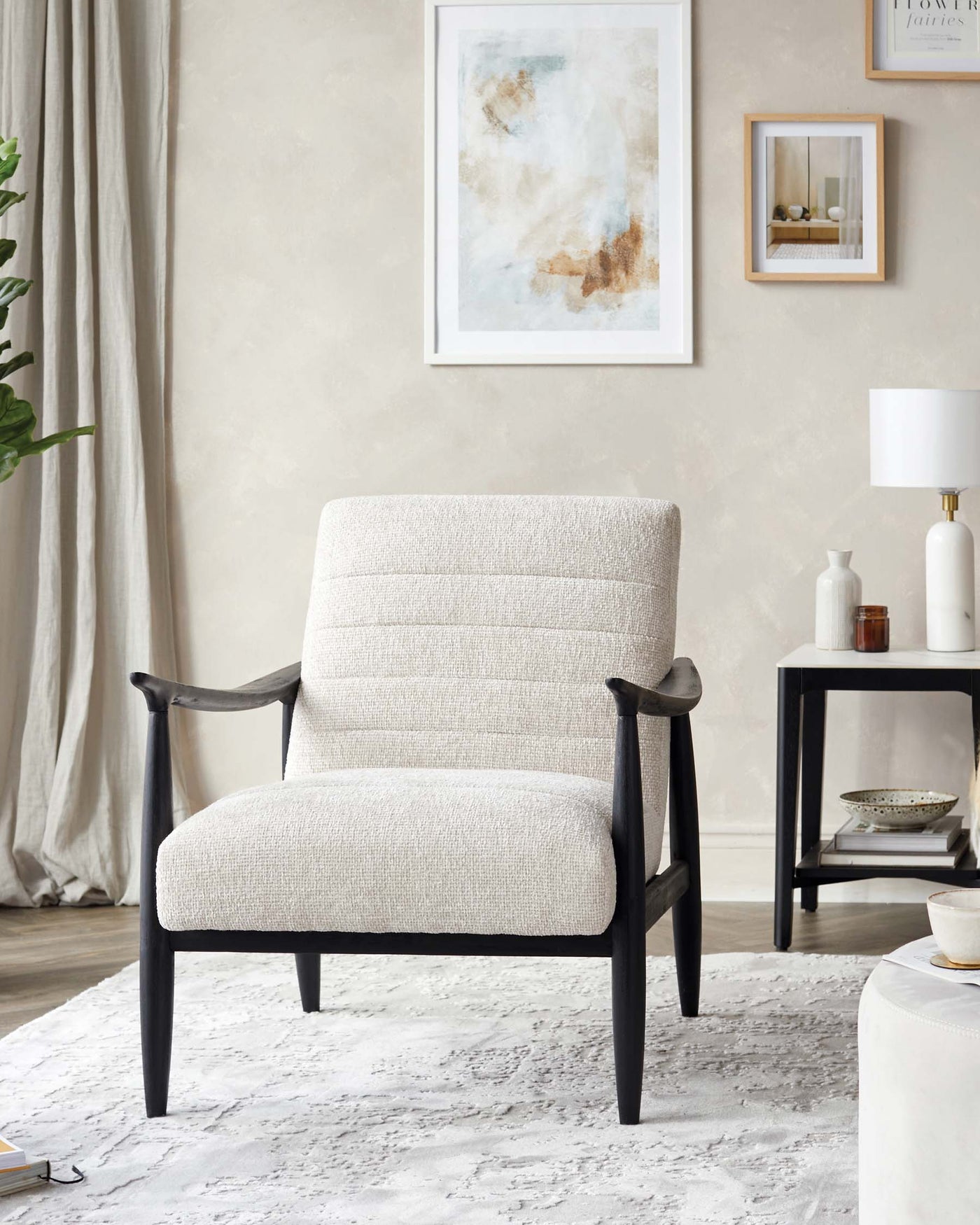 Elegant contemporary accent chair with a beige textured fabric upholstery and sleek black wooden frame, complemented by a minimalist black side table with a lower shelf, set in a stylish room with decorative accents.