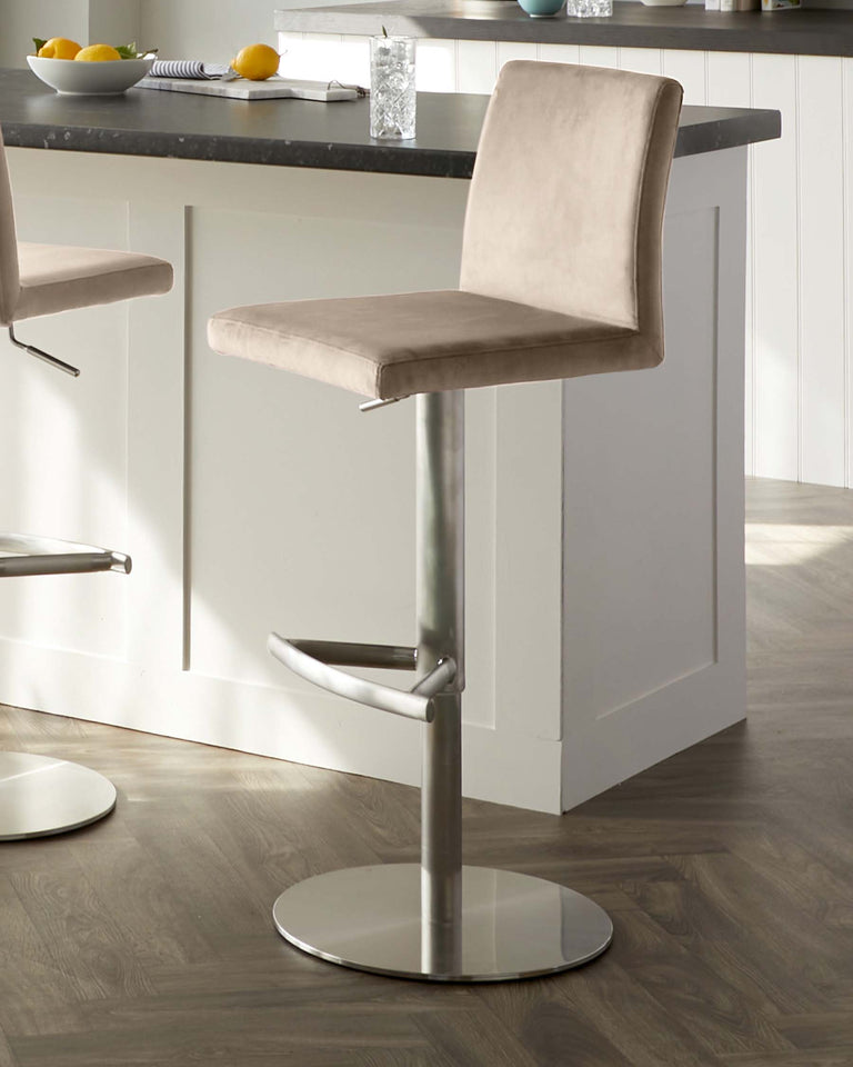 Modern adjustable bar stool with a beige suede-like fabric seat, featuring a low backrest, a sleek chrome base, and a built-in footrest.