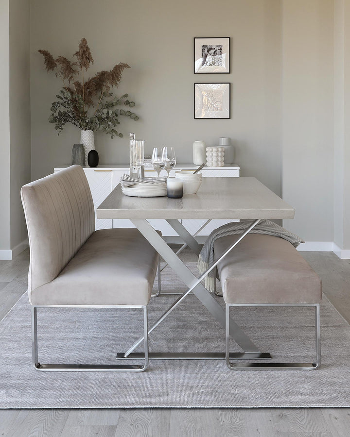 Dining set with a light grey table, bench and sofa on a grey rug, in front of a sideboard with art on the wall above.
