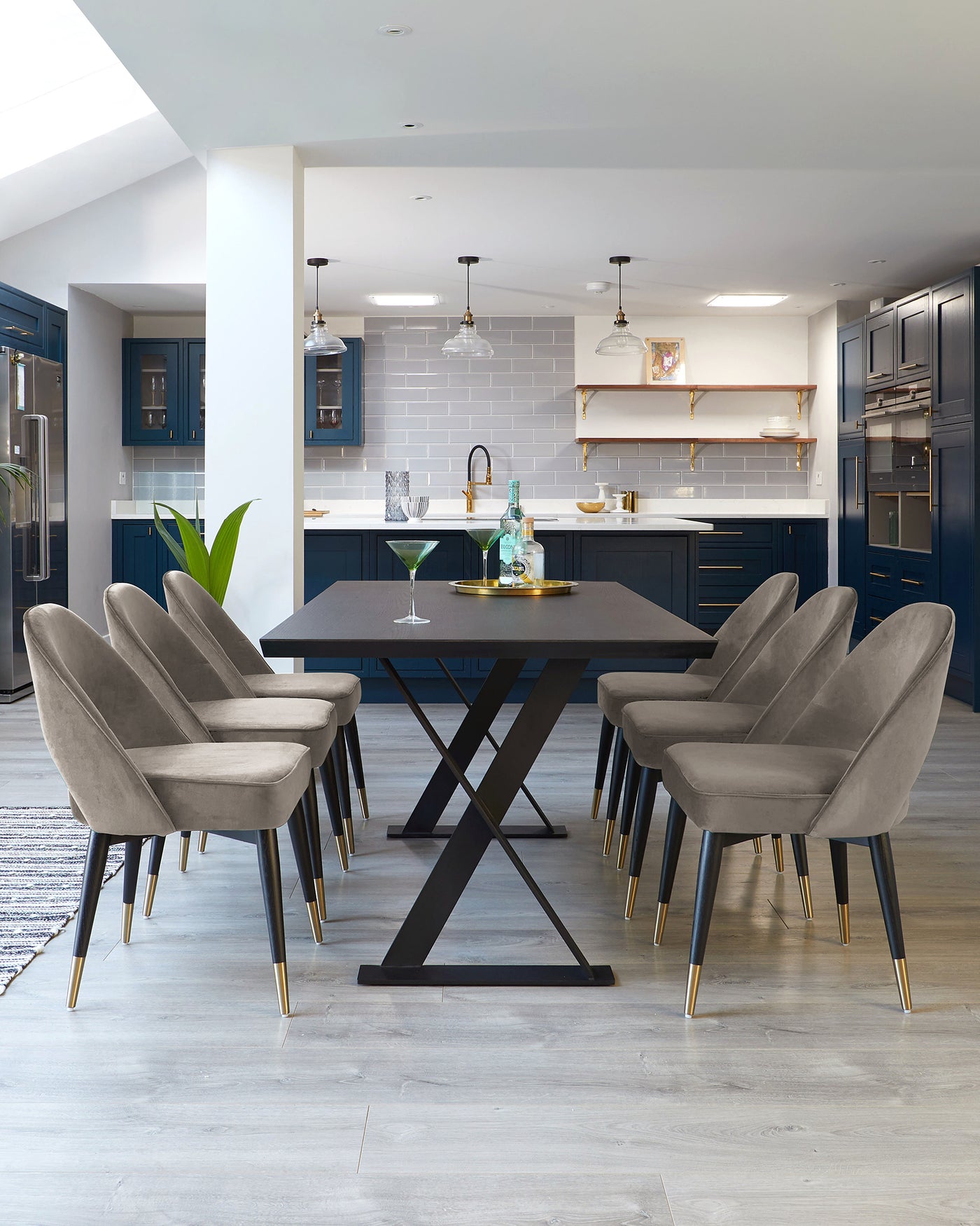 Modern dining set featuring a black rectangular table with a matte finish and robust X-shaped legs. Accompanied by six elegant grey upholstered chairs with channel tufting on the backrest, slender black frames, and contrasting gold-finished metal tips on the legs. Perfect for a contemporary dining space.