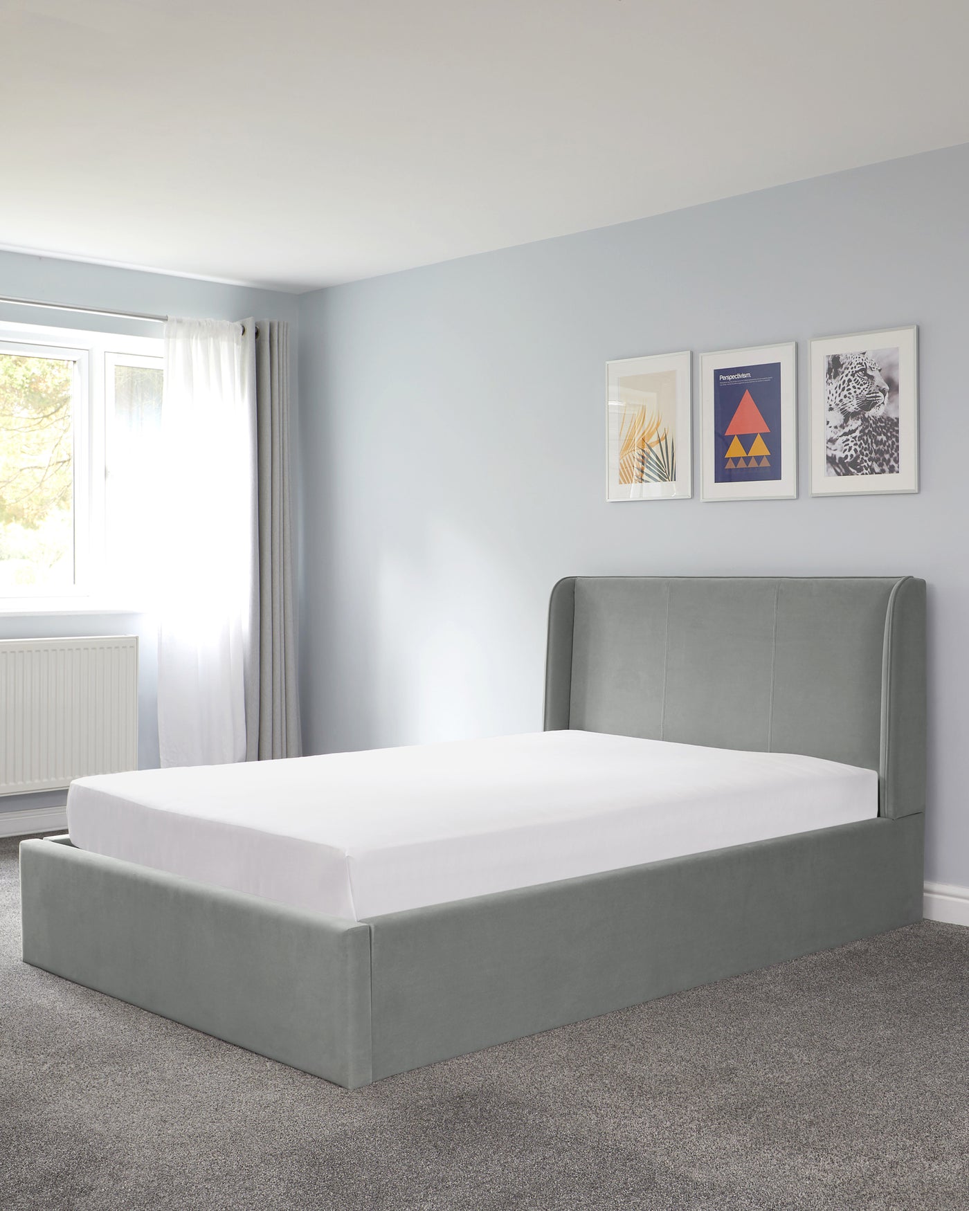 A modern grey upholstered bed frame with a gently curved headboard and no visible beddings or pillows.