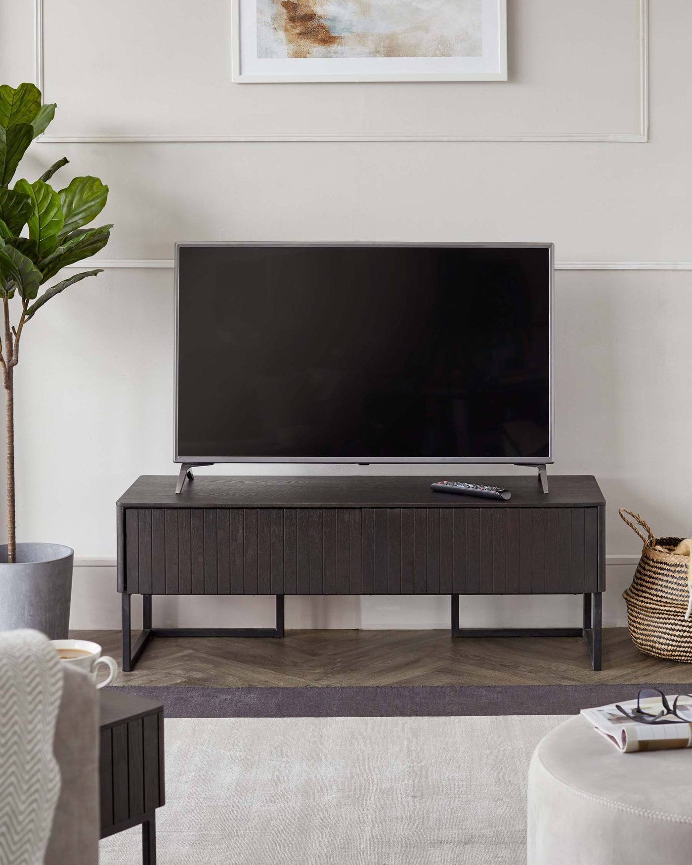 Modern dark wood media console with sleek metal legs, featuring a minimalist design and clean lines, ideal for supporting a television and accompanying electronics.
