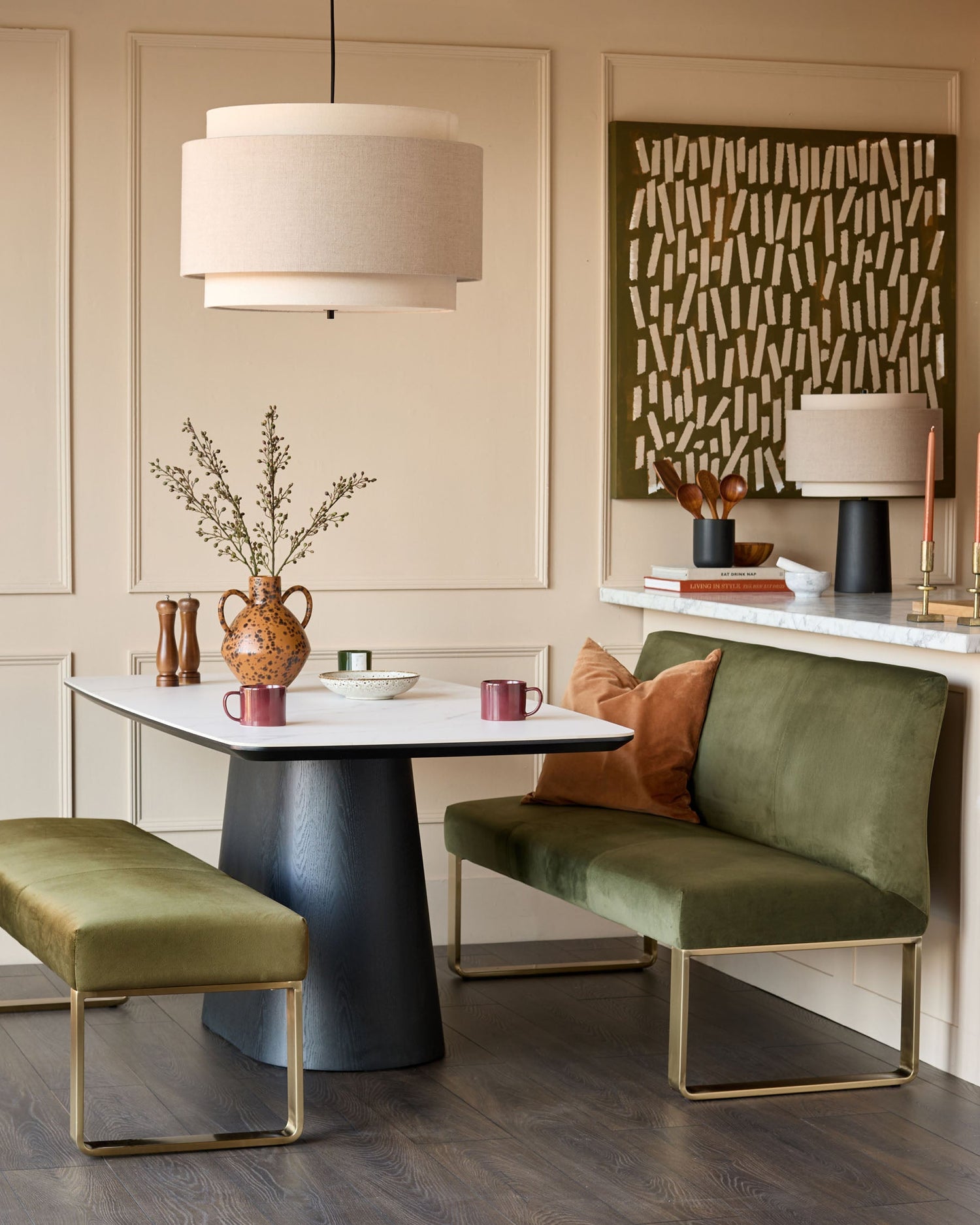 Olive-green velvet bench without backrest, brushed brass frame, shown in modern dining setting with coordinating seating.