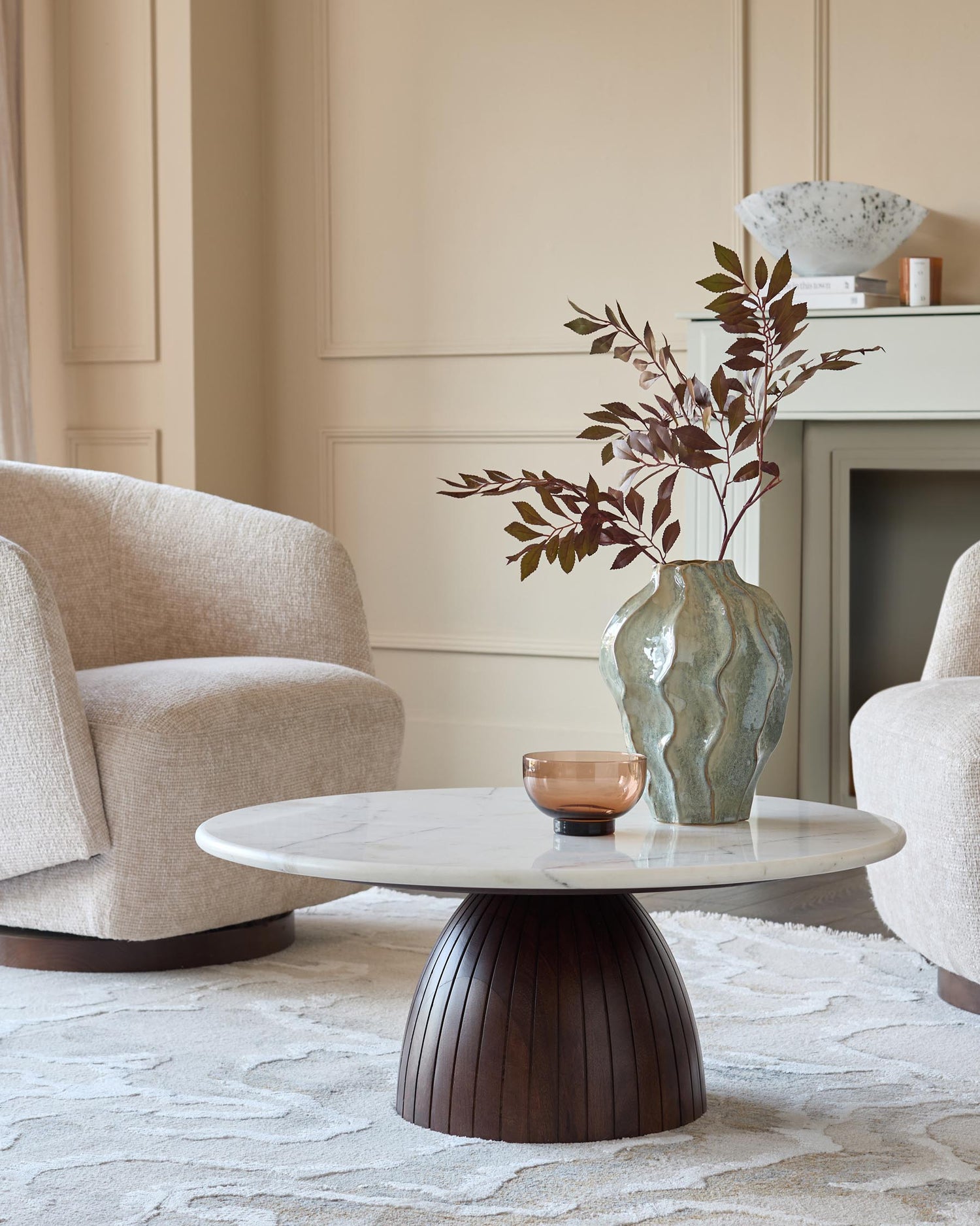 Malin coffee table with white marble top and dark mango wood fluted pedestal base, styled in modern living room.