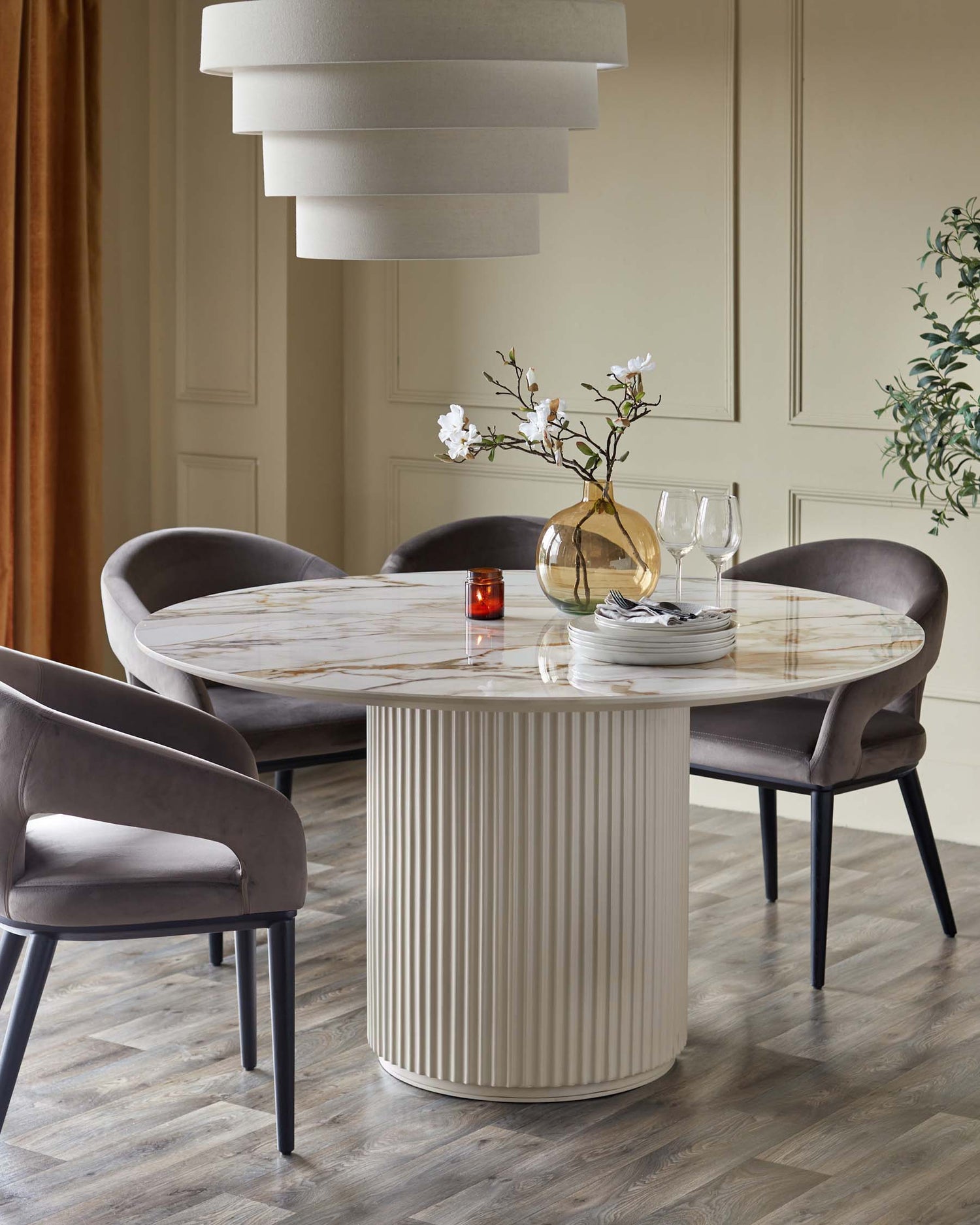 Austin natural ceramic round dining table with Heath mocha chairs in modern dining room setting.