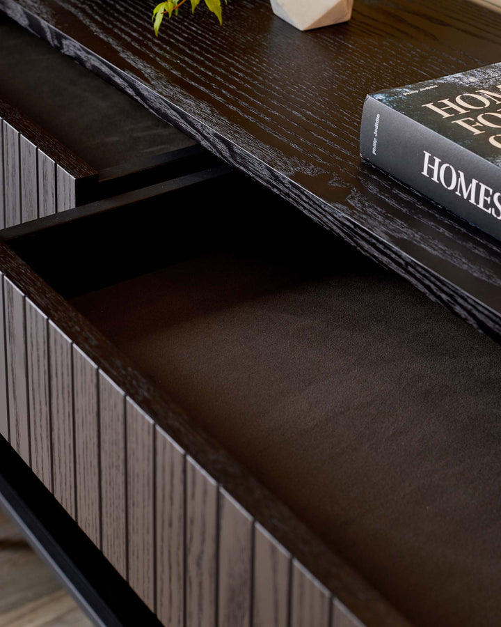 Dark wood console table with a drawer pulled out, showing storage space. A stylish, modern storage solution.