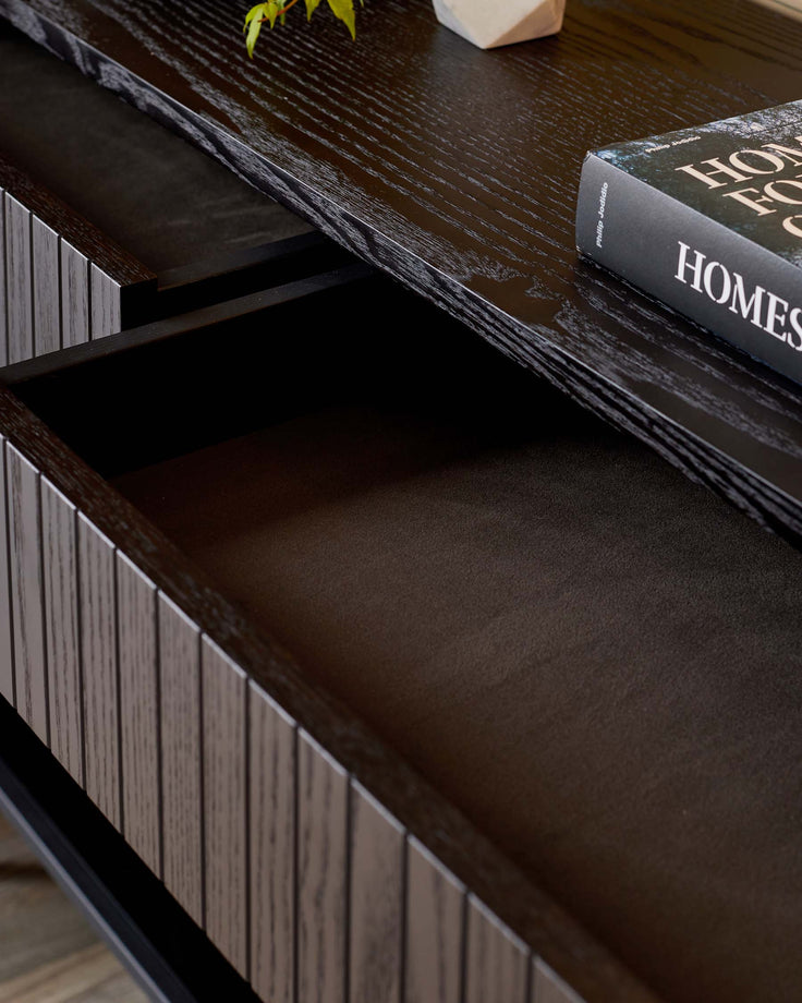 Dark wood console table with a drawer pulled out, showing storage space. A stylish, modern storage solution.